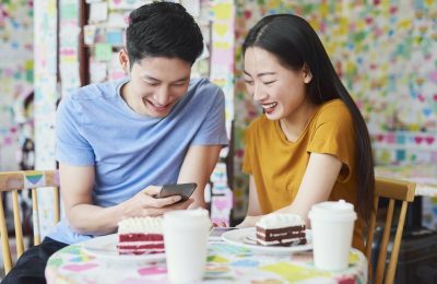 Vietnamese couple enjoying the free internet in a cafe